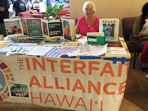 literature table with TIAH banner and smiling TIAH representative