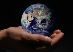 Earth from space in cupped human hands; photo illustration by Brittany Barker)